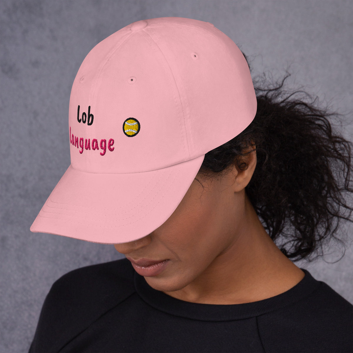 Pink padel dad cap with the Lob Language design embroidered on the front, left side view