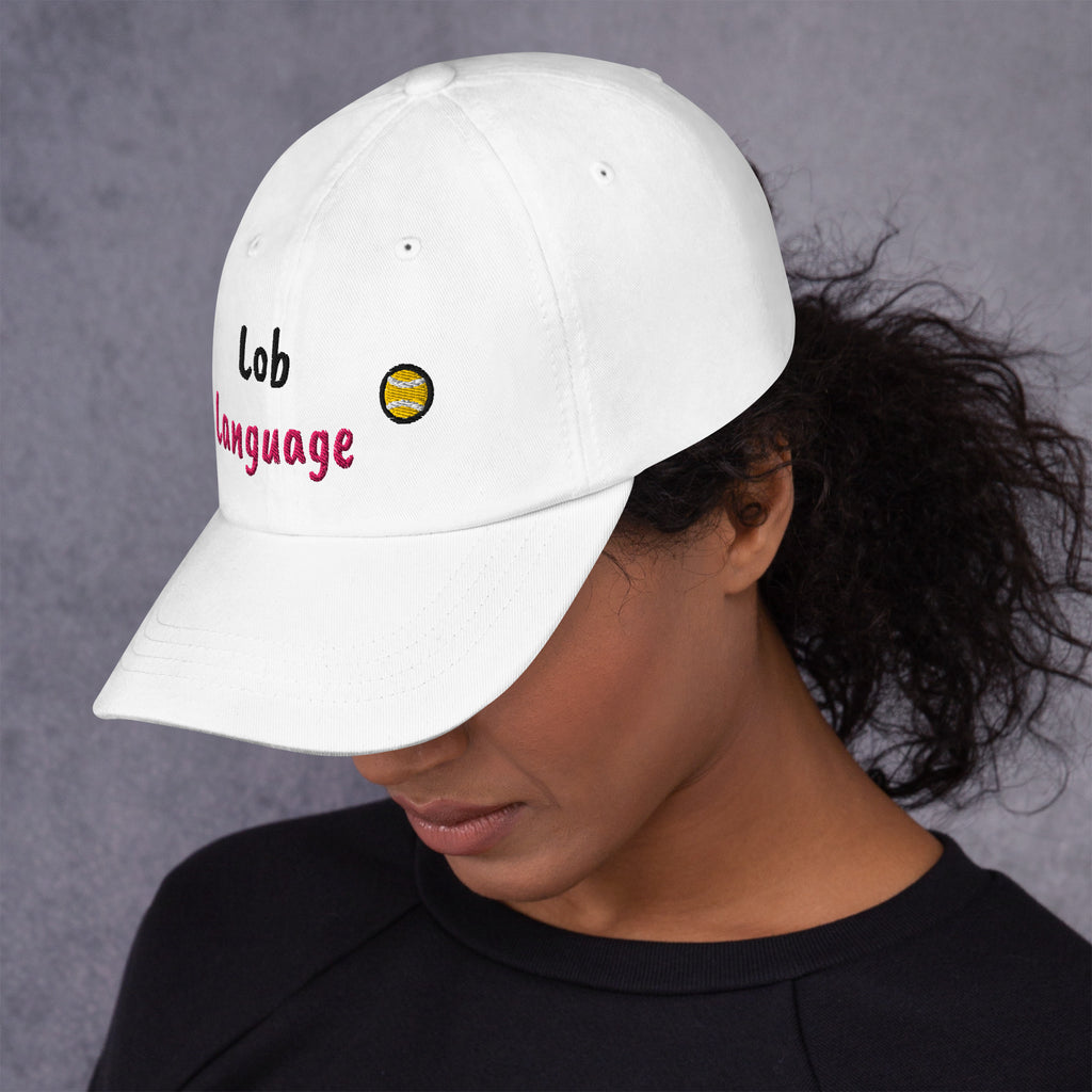 White padel dad cap with the Lob Language design embroidered on the front, left side view